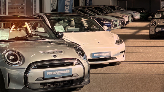 En række brugte biler, herunder en Mini og en Tesla, er udstillet i PreLovedCars showroom.