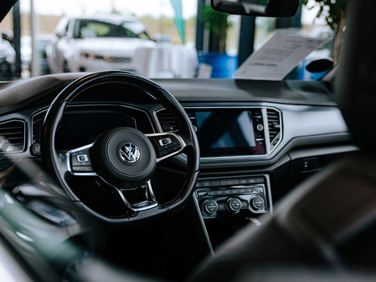 Interiørbillede af en Volkswagen-bil med tydeligt rat, instrumentbræt og moderne infotainmentsystem.